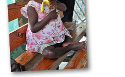 Little Girl in Nutrition Center Earting a Banana