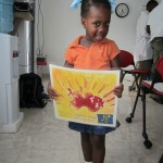 little girl with hand hygiene poster